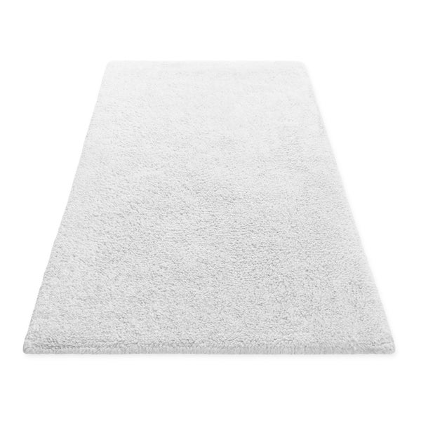 Rechteckiger weißer Hochflor-Teppich.