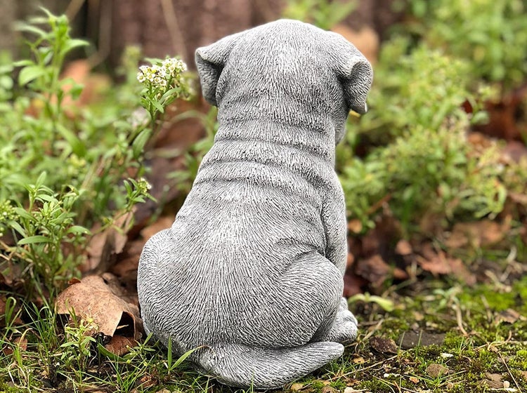Gartenfigur in Form eines sitzenden Welpen aus wetterfestem Steinguss zur Dekoration im Außenbereich.