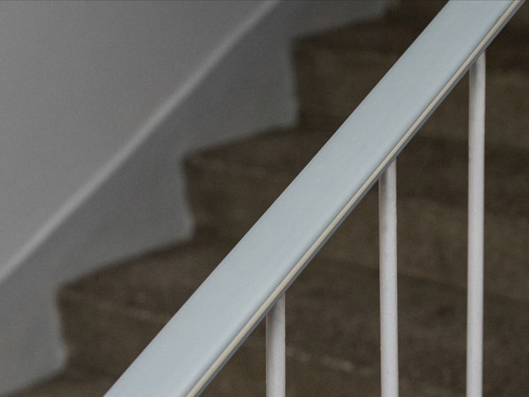 Detailaufnahme eines Treppengeländers mit Stufen im Hintergrund