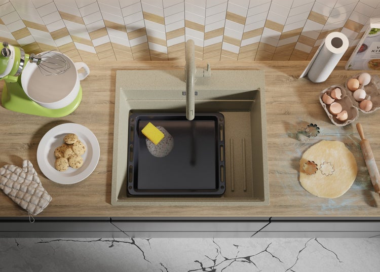 Spüle mit Backblech und Spülschwamm auf Küchentheke mit Speisen und Küchengeräten