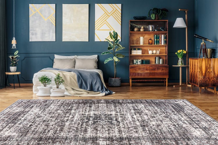 Moderner Raum mit großem gemustertem Teppich, Holzmöbeln und gemütlichem Bett. Pflanzen und Dekoration ergänzen die stilvolle Einrichtung.