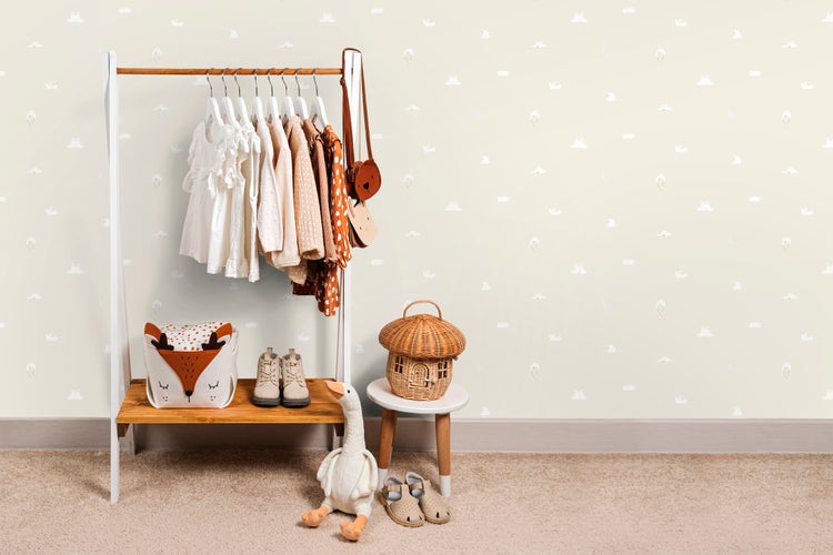 Kinderzimmer mit Kleiderständer, Kleidung, Spielzeug und Dekorationen