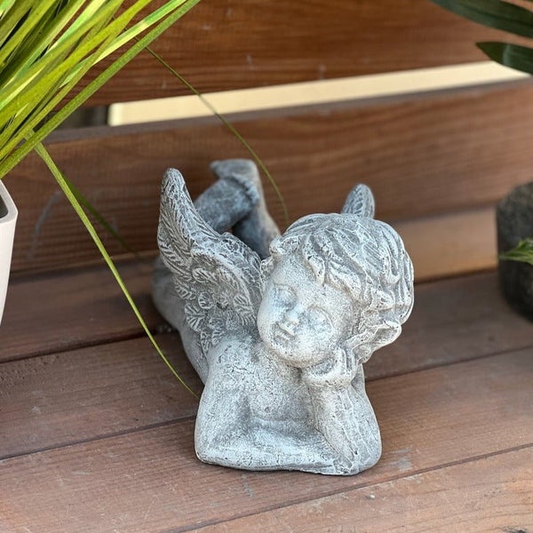 Dekorative Gartenfigur in Form eines liegenden Engels aus witterungsbeständigem Material für die Außengestaltung.
