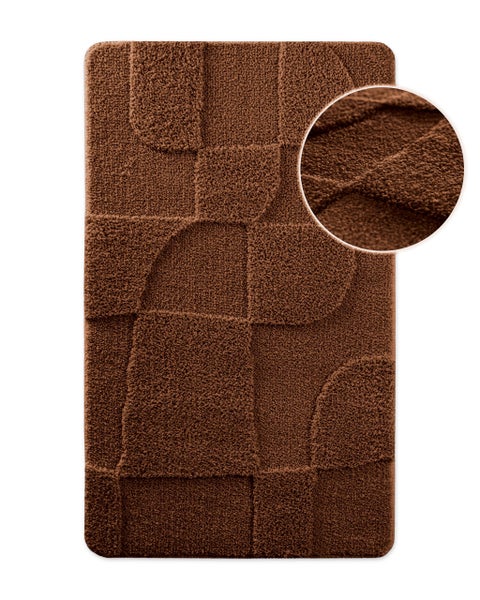 Braune Badematte mit geometrischem Reliefmuster und einer Detailansicht der weichen Oberfläche.