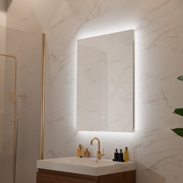 Beleuchteter Wandspiegel mit LED Beleuchtung in einem modernen Badezimmer mit Marmoroptik und goldfarbener Armatur.