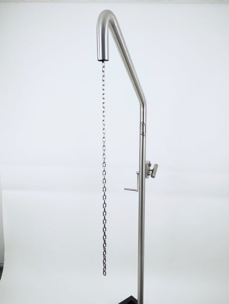 Schwenkgrill mit Stativ und Holz über Pflastersteinen