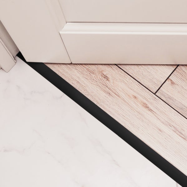 Boden mit Übergangsprofil zwischen Fliesen und Laminat.