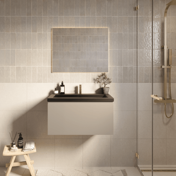 Modernes helles Badezimmer mit beigem hängendem Waschtischunterschrank, schwarzem Waschbecken, goldener Armatur und hinterleuchtetem Spiegel.