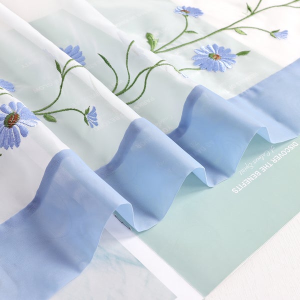 Gardinenstoff mit Blumenstickerei und blauem Saum