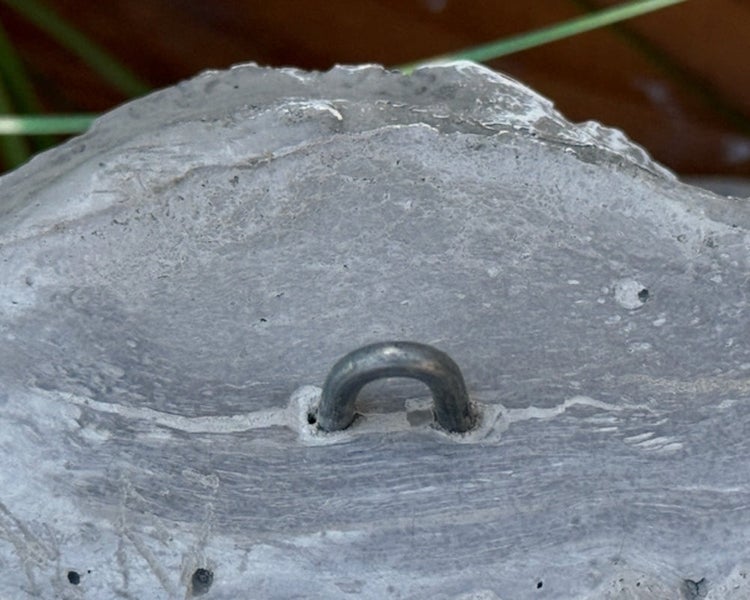 Betonstein mit integriertem Metallaufhänger zur Wandbefestigung