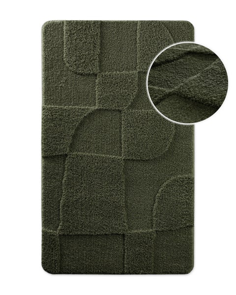Rechteckige dunkelgrüne Badematte mit geometrischem Reliefmuster und weicher Textur.