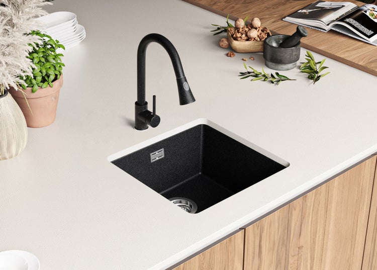 Küchenszene mit schwarzer Spüle und Armatur in einer hellen Arbeitsplatte