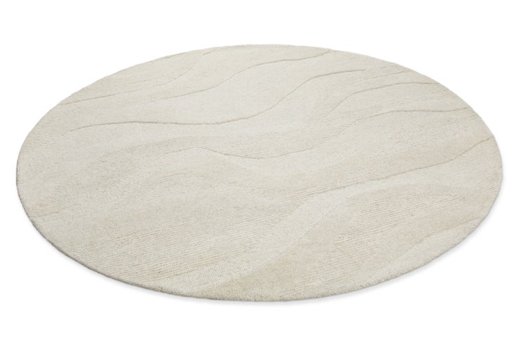 Runder beige Teppich mit Wellenstruktur und Hoch-Tief-Effekt.