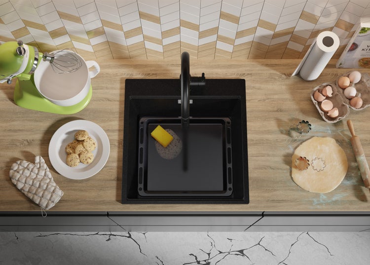 Küchenszene mit Spüle, Armatur und Küchenutensilien auf einer Arbeitsplatte.