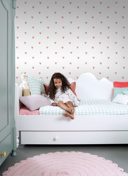 Mädchenzimmer mit Bett, Textilien und Herzchentapete