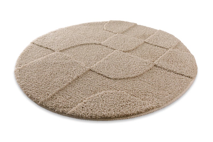 Runder beigefarbener Hochflor-Teppich mit strukturiertem Wellenmuster.
