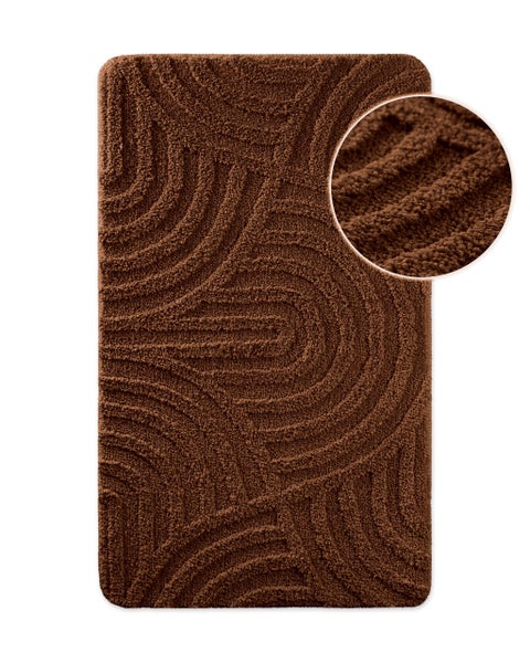 Rechteckiger Badteppich in Braun mit geschwungenem Wellenmuster und Detailansicht der weichen Textur.