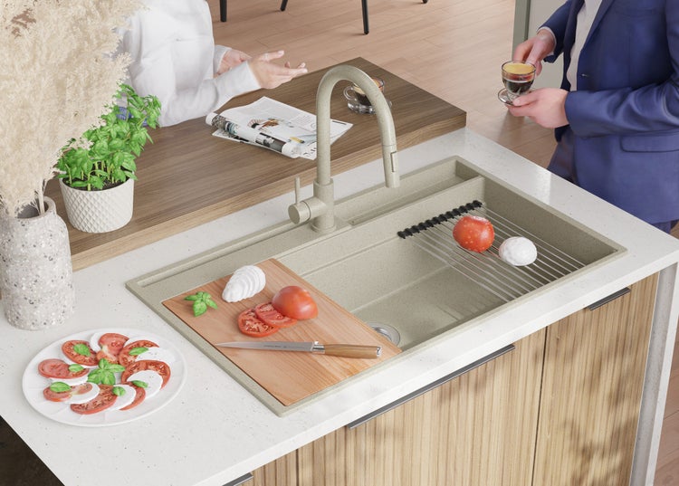 Küchenszene mit Spüle, Armatur, Schneidebrett, Tomaten und Mozzarella auf einer Arbeitsplatte.