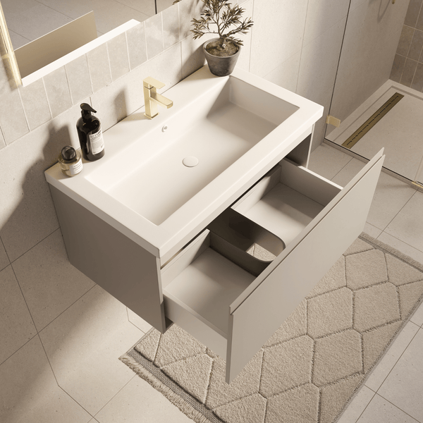 Moderner wandhängender Waschtisch mit weißem Waschbecken, goldener Armatur und geöffneter Schublade in einem hellen Badezimmer.