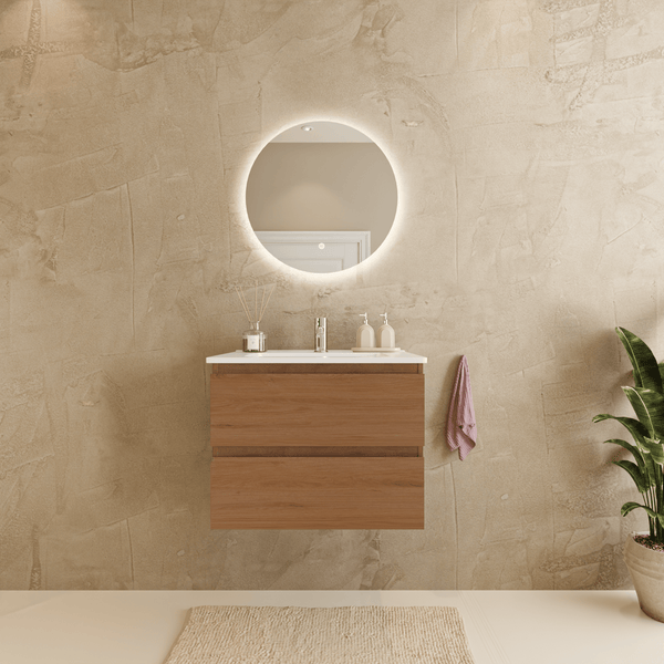 Wandhängender Waschbeckenunterschrank in Holzoptik mit weißem Waschbecken und beleuchtetem Rundspiegel in einem modernen Badezimmer.
