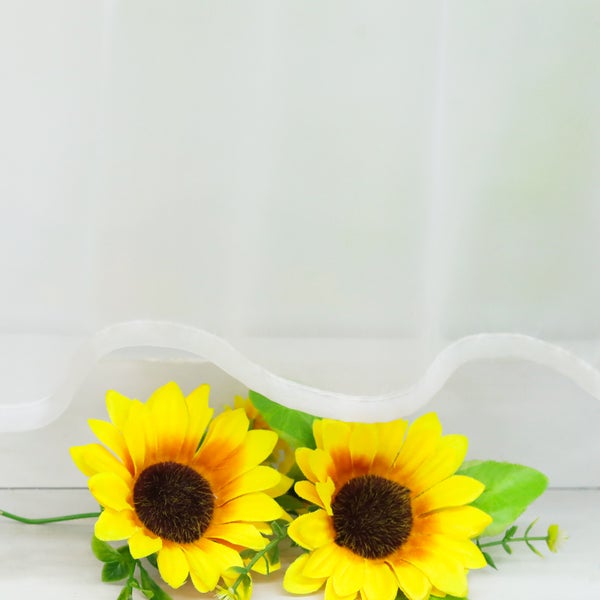 Dekorative Sonnenblumen mit Stoffblättern vor hellem Hintergrund
