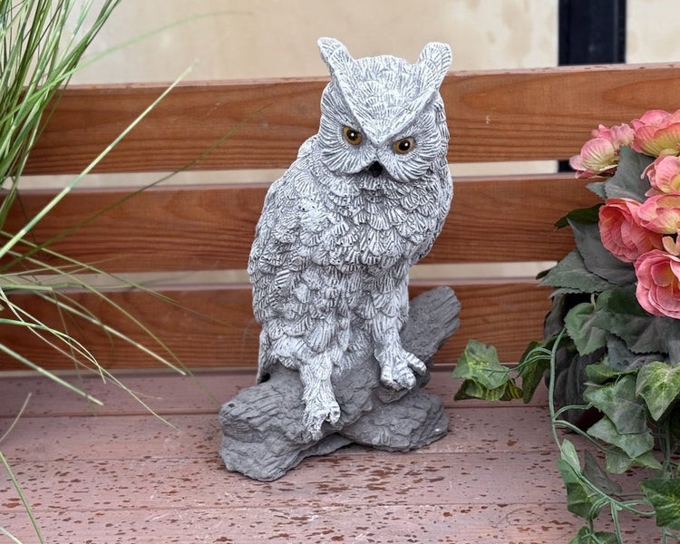 Gartenfigur einer detailreichen Eule auf einem Ast in grauer Steinoptik.