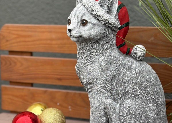 Dekorative Katzenfigur mit Weihnachtsmütze als Garten- oder Wohndekoration aus wetterfestem Material.