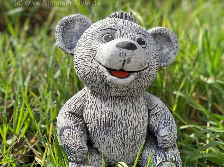 Dekorative Gartenfigur aus Stein in Form eines sitzenden Teddybären zur Gartendekoration.