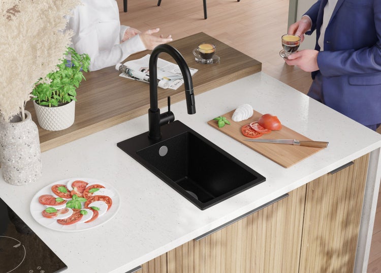 Spüle mit Armatur auf Küchentheke mit Speisen und Getränken.