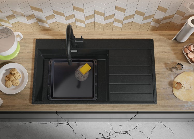 Küchenspüle aus Granit mit Geschirr und Speisen auf einer Küchentheke.