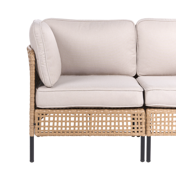 Detailansicht eines Rattansofas mit beigen Polstern und schwarzen Beinen