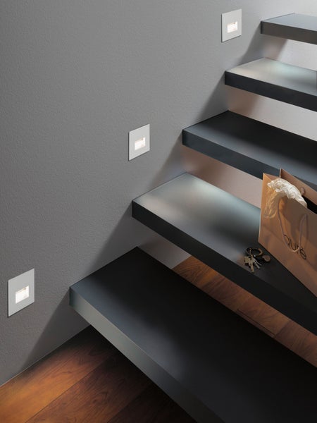 Treppenhaus mit eingelassenen Wandleuchten, Treppe, Schlüssel und Einkaufstasche