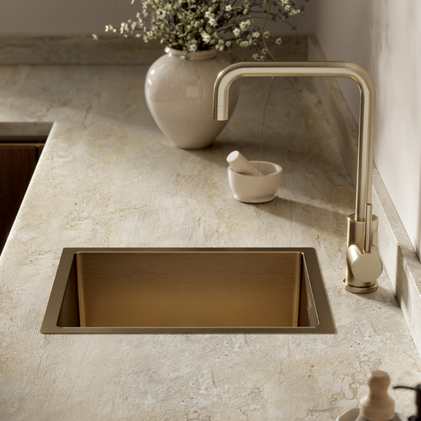Moderne Küchenspüle mit passender Einhebelarmatur in einer Steinoptik Arbeitsplatte mit Vase und Mörser als Dekoration.