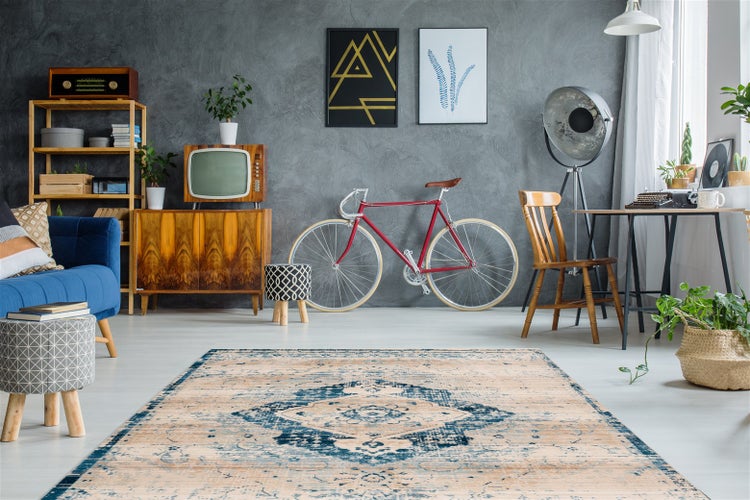 Nahaufnahme eines weichen Teppichs mit blauem Muster und umgeknickter Ecke zur Darstellung der Florstruktur.