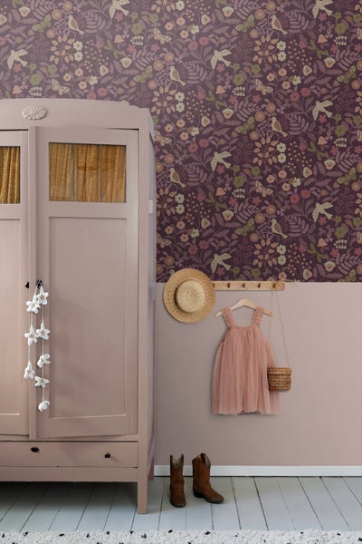 Zimmer mit einer floralen Tapete, einem Kleiderschrank, einem Hut, einem Kleid, einer Handtasche und Stiefeln