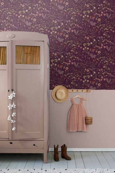 Szene mit floraler Tapete, Kleiderschrank, Kinderkleidung und Accessoires in einem Kinderzimmer
