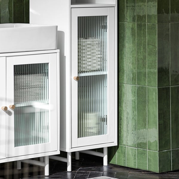 Badezimmer mit Waschbeckenunterschrank und Hochschrank mit Riffelglastüren