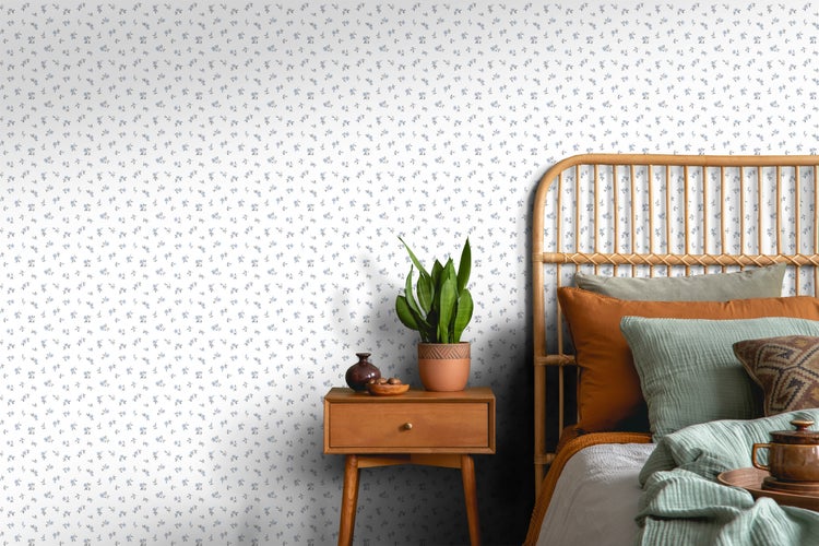 Schlafzimmer mit Rattanbett, Nachttisch und Blumentapete