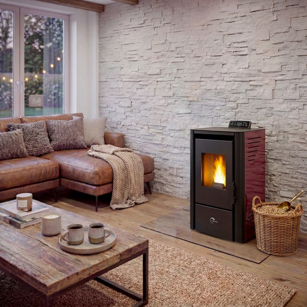 Pelletkaminofen in modernem Wohnzimmer mit Natursteinwand Ledersofa und Korb mit Holzpellets für behagliche Atmosphäre