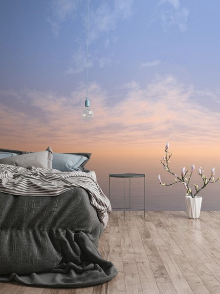 Schlafzimmer mit Bett, Nachttisch, Dekoration und Tapete mit Himmel-Motiv.