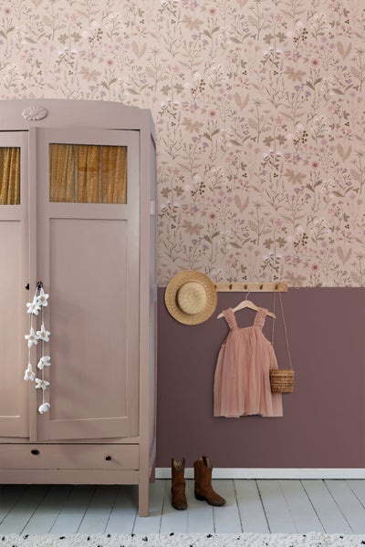 Kinderzimmer mit Kleiderschrank, floraler Tapete, Hut, Kleid, Tasche und Stiefeln.