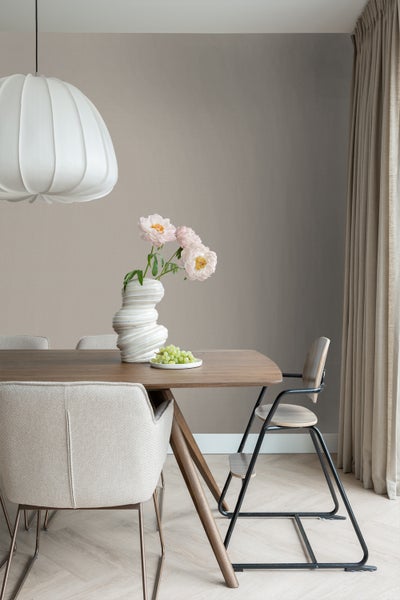 Esszimmer mit Holztisch, Stühlen, Lampe und Blumenvase