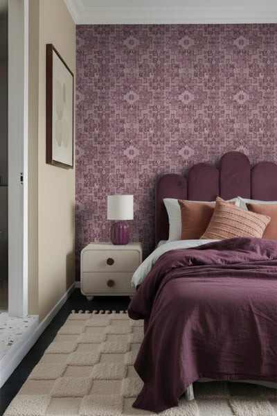 Schlafzimmer mit gemusterter Tapete, Bett, Nachttisch und Teppich