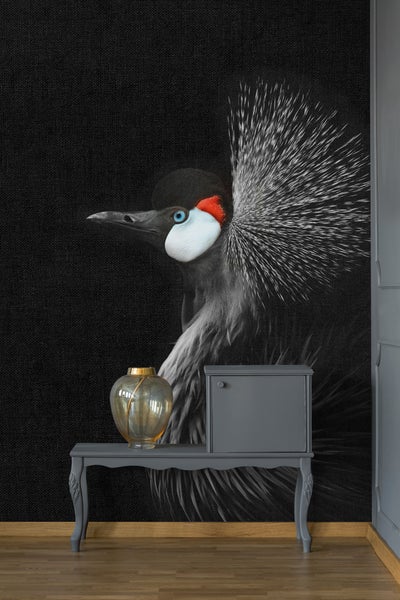 Vlies-Fototapete mit einem detailreichen Porträt eines Kronenkranichs in einem modern gestalteten Raum mit einer Konsole und einer Vase.