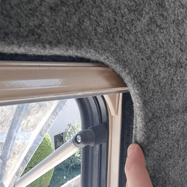 Detailansicht eines Fensterrahmens mit grauer Filzverkleidung