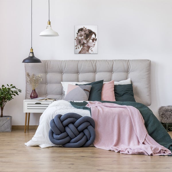 Schlafzimmer mit Bett, Kissen und einem an der Wand hängenden Bild