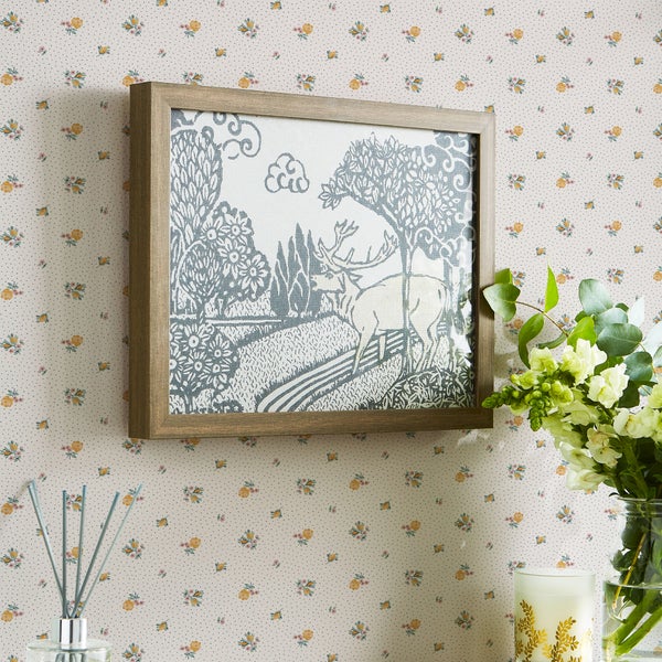 Wandbild mit Hirschmotiv im Holzrahmen, dekoriert vor einer floral gemusterten Tapete mit Blumenvasen und Duftstäbchen.