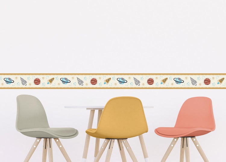 Tapetenbordüre für Kinderzimmer mit Weltraum-Motiven wie Planeten und Raketen über einem Kindertisch mit Stühlen.