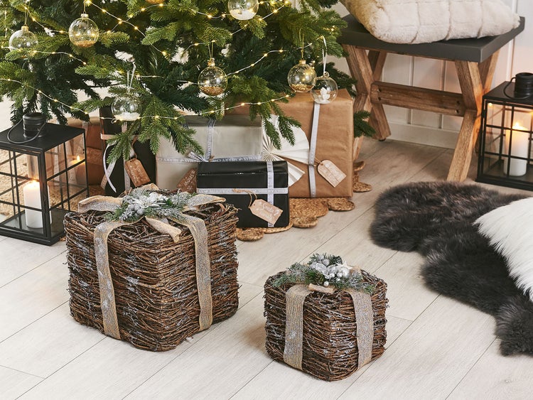 Dekorative Szene mit Weihnachtsbaum, Geschenken, Laternen und zwei geflochtenen Körben mit Schleifen