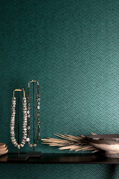 Raumansicht mit gemusterter Tapete, Dekoschmuck und Schale auf Ablage